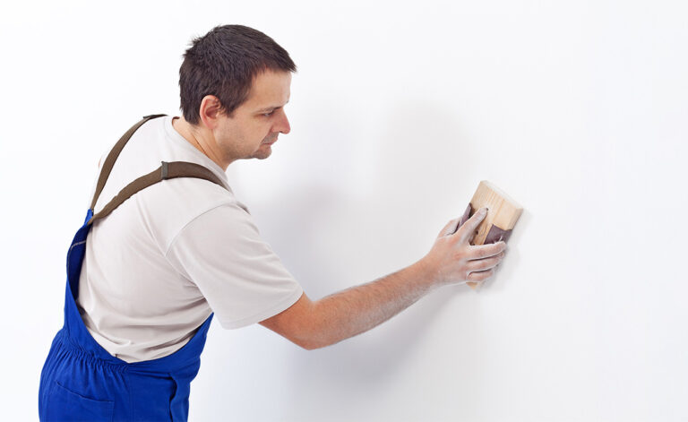Worker-Rubbing-First-Coat-Of-Putty-shutterstock