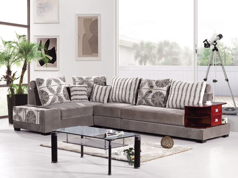 Wooden Right Arm Modern Sectional Chaise Sofa with Printed Cushions, Glazed Coffee Table placed over a Rug & Indoor Plant