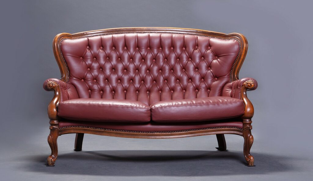 A vintage Victorian-style sofa in maroon leather