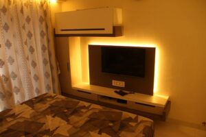 The Bedroom consists of Rectangular Wooden Bed & Wall Mounted T.V. Unit - 2