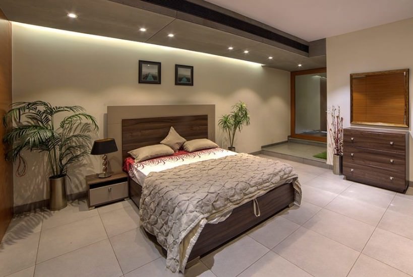 The Beige & Brown themed Bedroom consists of Rectangular Wooden Bed with Brown Backrest & Wooden Side Table