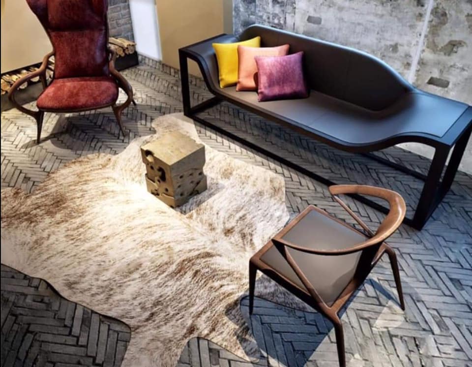 A Unique Black Sofa having Metal Framed Legs with the Maroon High Wingback Chair