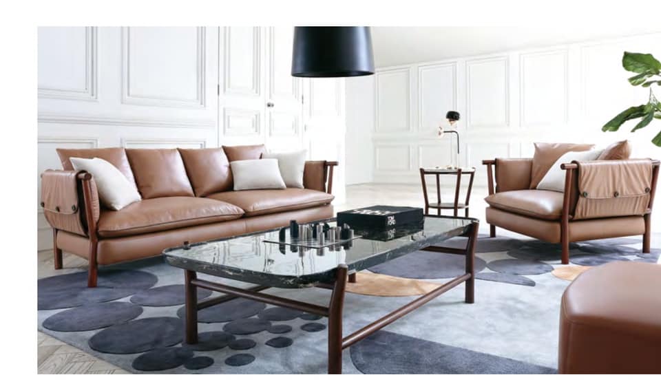 The 3-Seater & Single Seater Brown Leather Upholstered Sofa having Wooden Framed Legs are Nicely placed in the Living Room