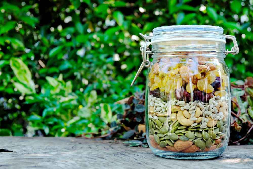 Filled Glass Container on Wooden Trunk Slice